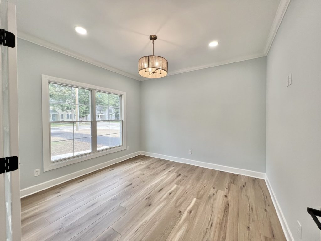 The Willow Front Den with Large Window, Drum Chandelier, Neutral Walls & Wood-Look Flooring