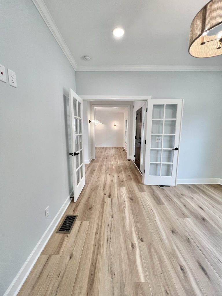 The Willow Den with Glass French Doors, Hallway View, Drum Chandelier & Wood-Look Flooring