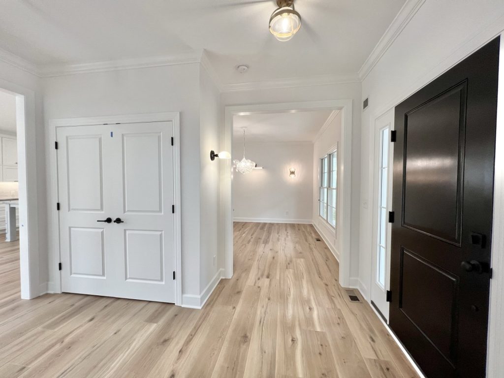 The Willow Front Entry Hall with Black Front Door, Double Doors, Wood-Look Flooring & Dining Room View