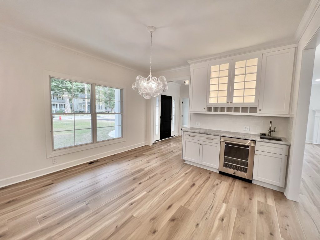 The Willow Kitchen and Dining area with Built-In Beverage Center, Large Window, Bubble Chandelier & Wood-Look Flooring