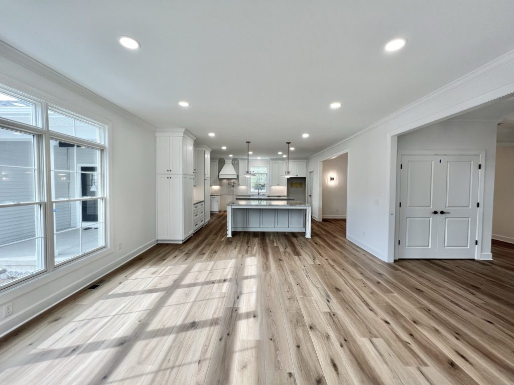 The Willow Kitchen with Oversized Island, White Cabinetry, Pendant Lighting & Wood-Look Flooring