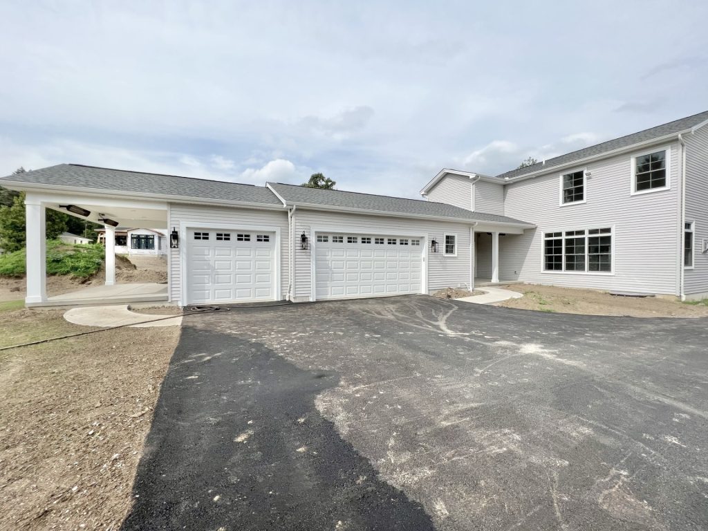 The Willow Front Exterior Angle with Attached 2-Car Garage, Side Entry Porch, Light Gray Siding & Asphalt Driveway