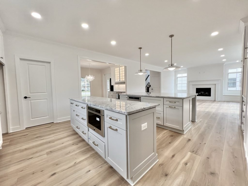 The Willow Kitchen with Two Islands, White Cabinetry, Marble Countertops and Fireplace View