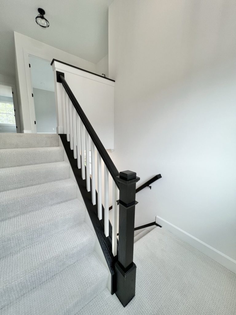TheWillow with Staircase with Light Carpet, Dark Railing to Upstairs Landing with Window