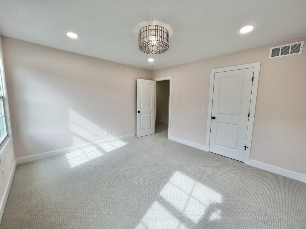 The Willow Bedroom with Rose Colored Walls, Light Carpet, Drum-Style Chandelier, Recessed Lighting, White Closet Door and Sunlight