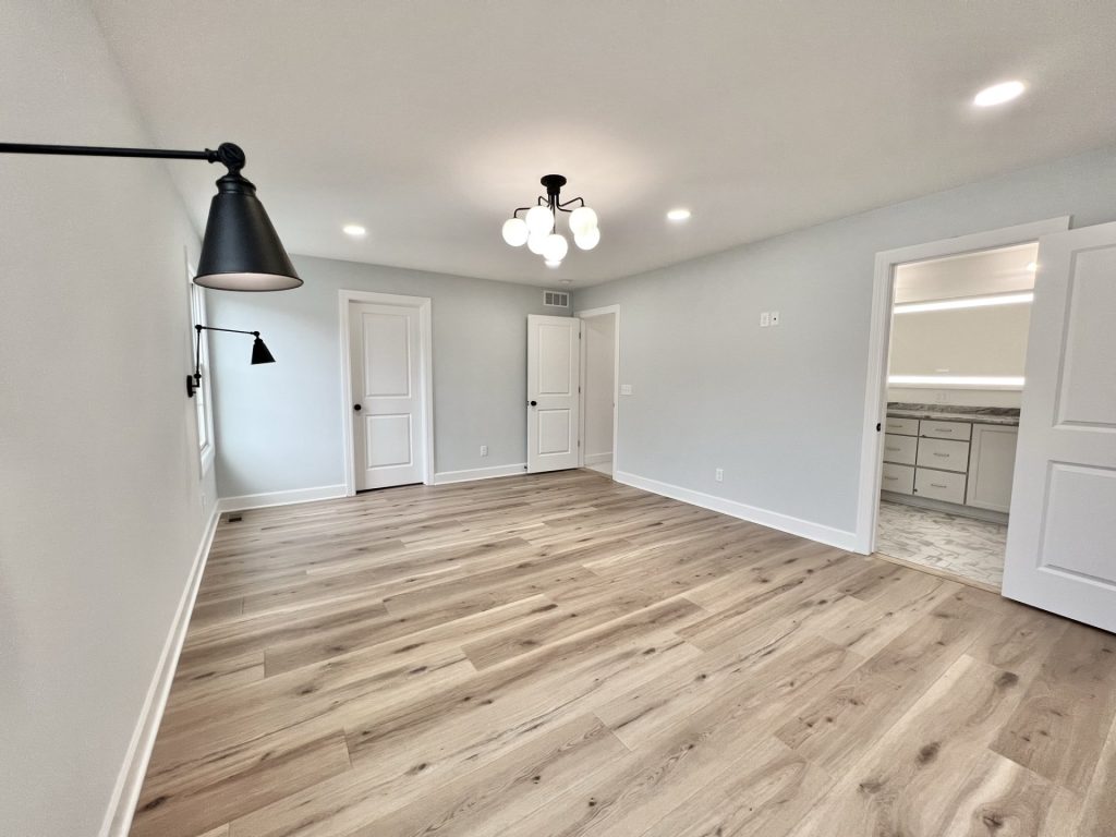 The Willow Master Bedroom with Master Bathroom View, Globe Chandelier, Closet Door, and Wall Sconces