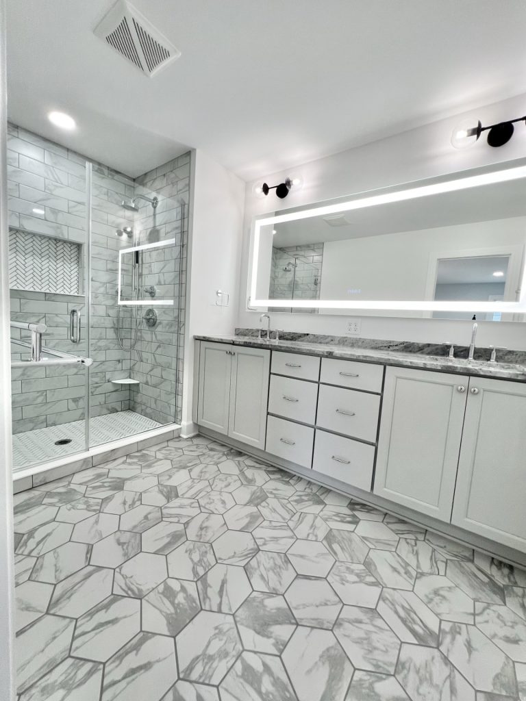 The Willow Master Bathroom in Gray and White Mosaics and Double Vanity with Dramatic Lighting Mirror Combo