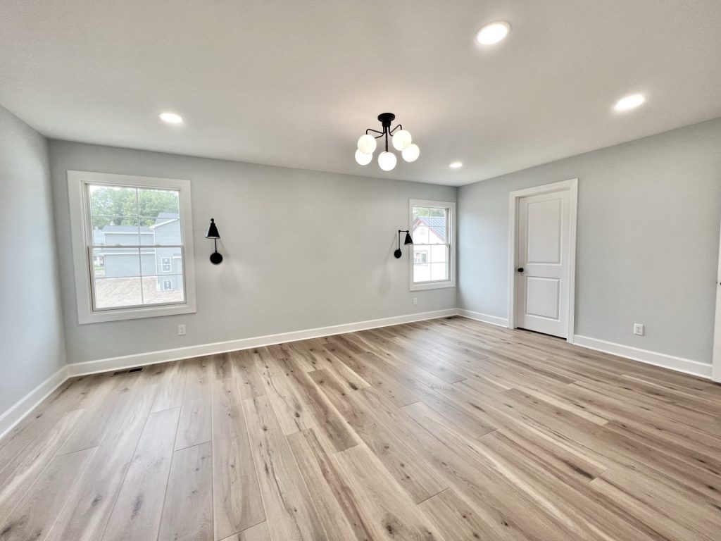 The Willow Master Bedroom with Pale Gray Walls, Wood Style Flooring, Windows and Overhead Lighting with Wall Sconces