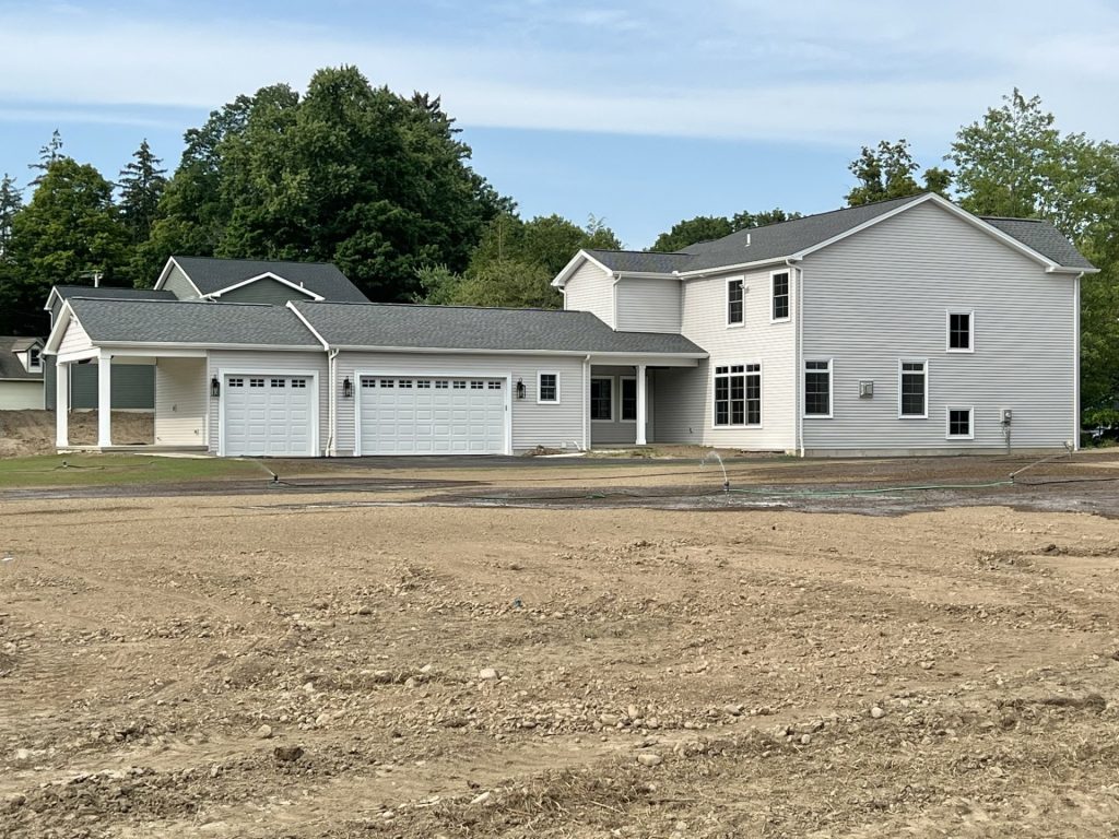 The Willow Rear Exterior with Light Gray Siding, Covered Porch, 3-Car Garage & Two-Story Rear Elevation