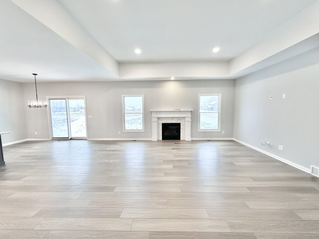 The Kendall Great Room with Fireplace, Sliding Glass Door, Wood-Look Flooring & Open Layout