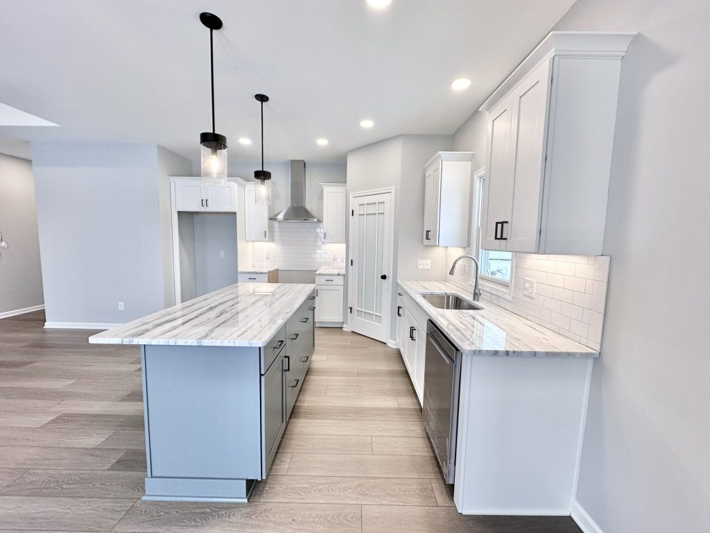 The Kendall Kitchen with Gray Island, White Cabinetry, Quartz Counters, Subway Tile Backsplash & Wood-Look Flooring