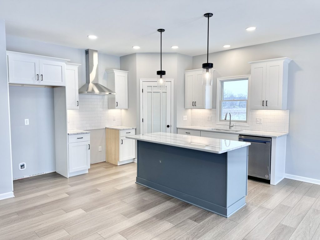 The Kendall Kitchen with Gray Island, White Cabinetry, Stainless Hood, Pendant Lights & Quartz Counters