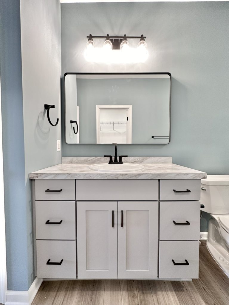 The Kendall Primary Bath Vanity with Gray Cabinetry, Black Faucet, Large Mirror & Tile Flooring
