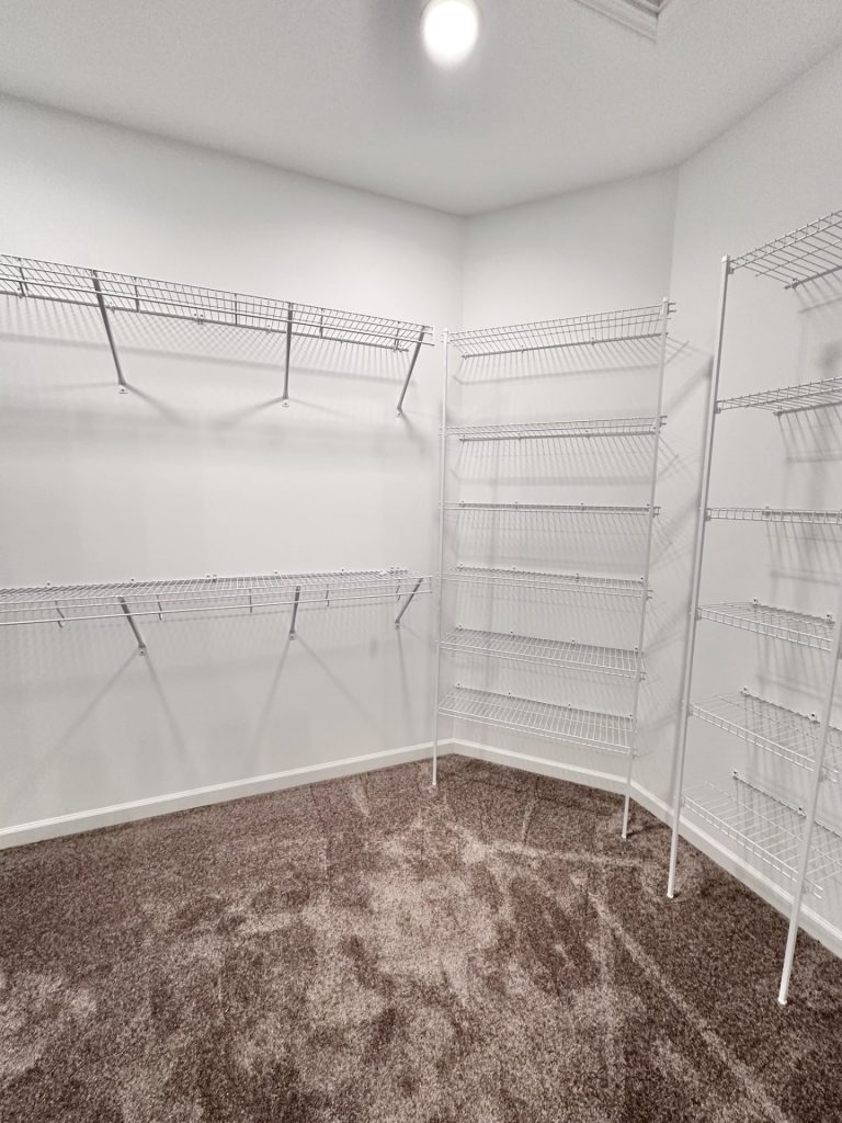The Kendall Walk-In Closet with Wire Shelving, Gray Carpet, White Walls & Multiple Storage Shelves