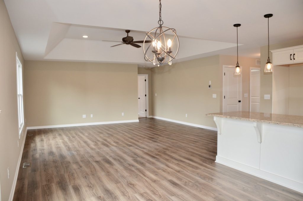 Baybrook-I-Great-Room-and-Kitchen-with-Tray-Ceiling-Pendant-Lights-Chandelier-and-Granite-Peninsula