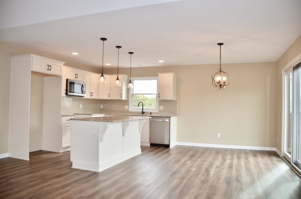 Baybrook-I-Kitchen-and-Dinette-with-White-Cabinetry-Center-Island-Sliding-Glass-Door-and-Wood-Look-Flooring