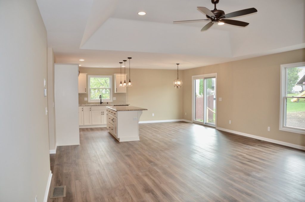 Baybrook-I-Open-Great-Room-and-Kitchen-with-Tray-Ceiling-Center-Island-Sliding-Glass-Door-and-Large-Windows