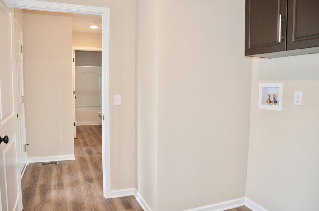 Baybrook-I-Mudroom-Hallway-with-Wood-Look-Flooring-Laundry-Hookups-and-Bathroom-View