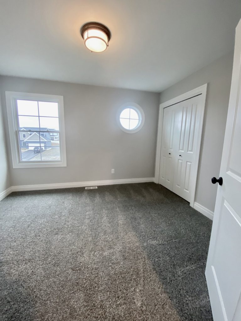 The Cooper II Secondary Bedroom with Gray Carpet, Round Window, Tall Window & Double Closet Doors