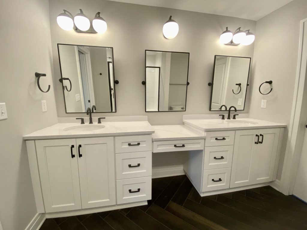 The Cooper II Double Vanity with Makeup Station, White Cabinetry, Black Fixtures & Dark Herringbone Tile Floor
