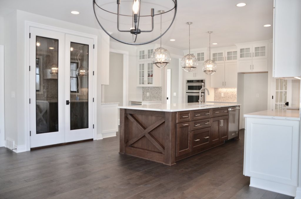 The Stratford II Kitchen with Large Island, Glass Pantry Doors, Modern Chandelier & White Cabinetry