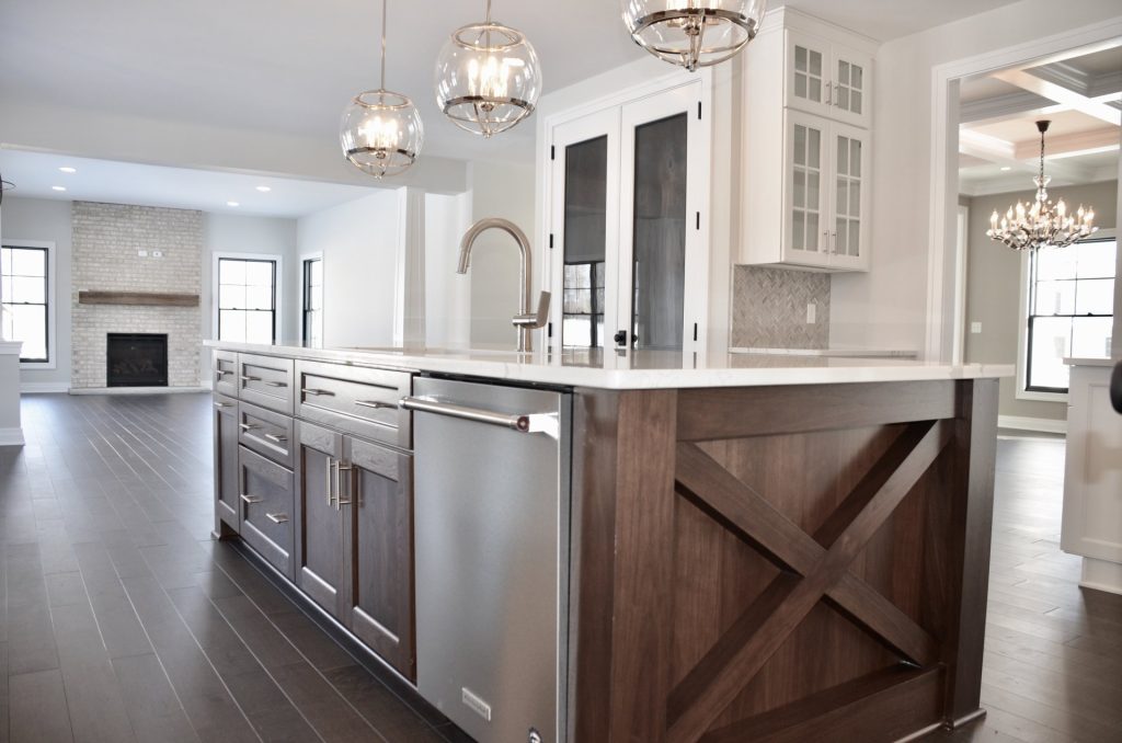 The Stratford II Kitchen Island with Sink, Fireplace View, Dining Room Entry & Dark Wood Flooring