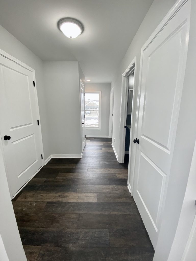 The Cooper I Hallway with Wood-Look Flooring, White Doors, Gray Walls & Window View