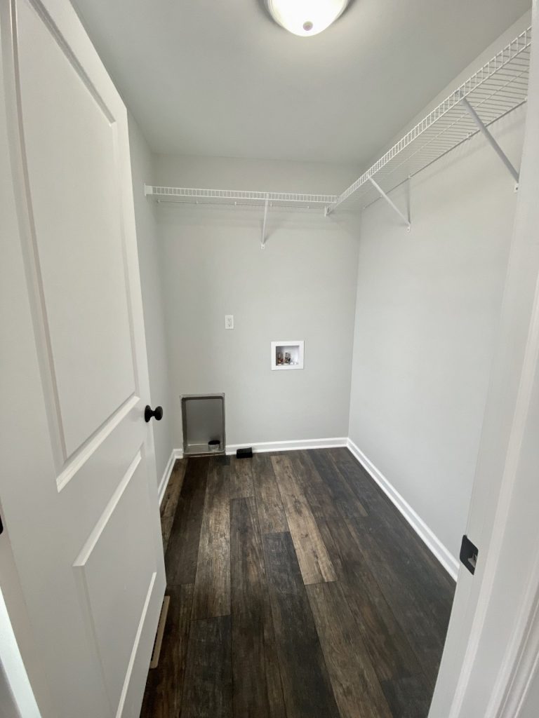 The Cooper I Laundry Room with Wood-Look Flooring, Wire Shelving, Utility Hookups & White Walls