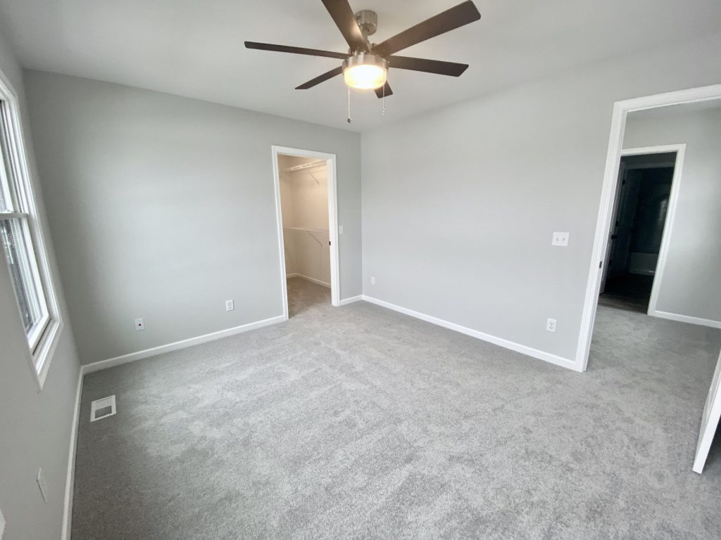 The Cooper I Secondary Bedroom with Light Carpet, Walk-In Closet, Hall Entry & Ceiling Fan