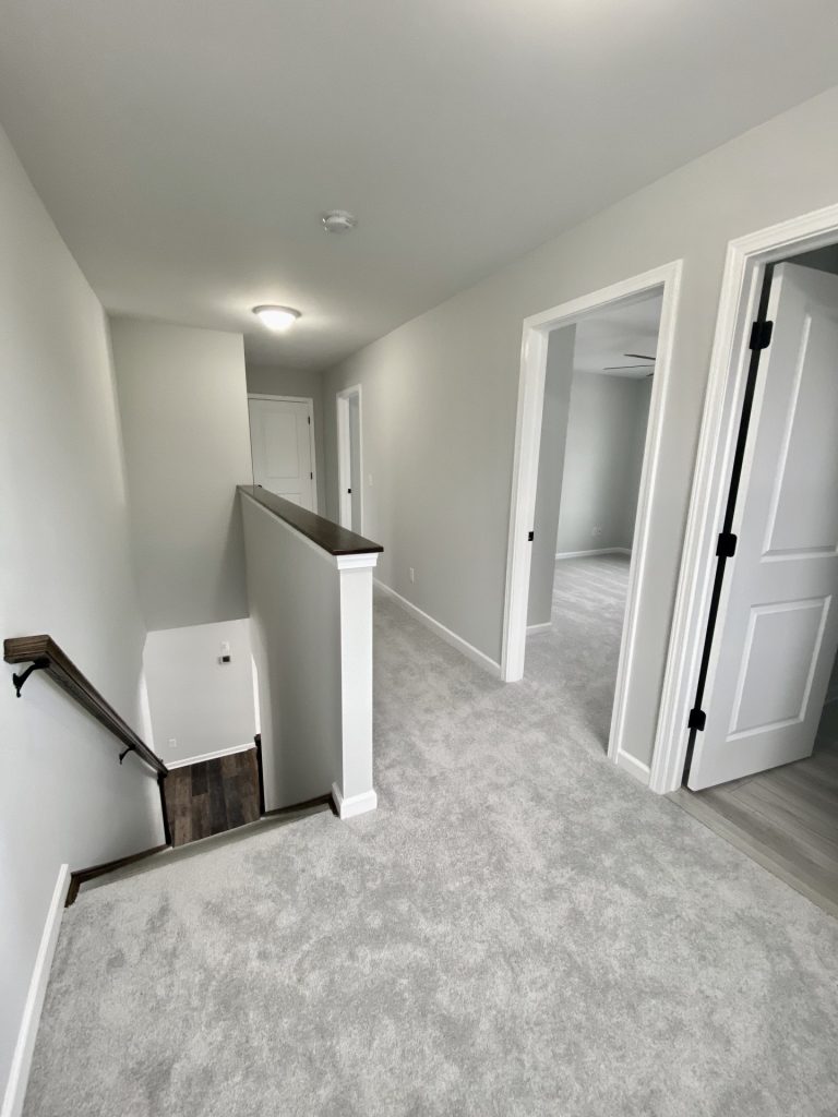 The Cooper I Upper Hallway with Light Carpet, Stair Opening, White Trim & Bedroom Entries