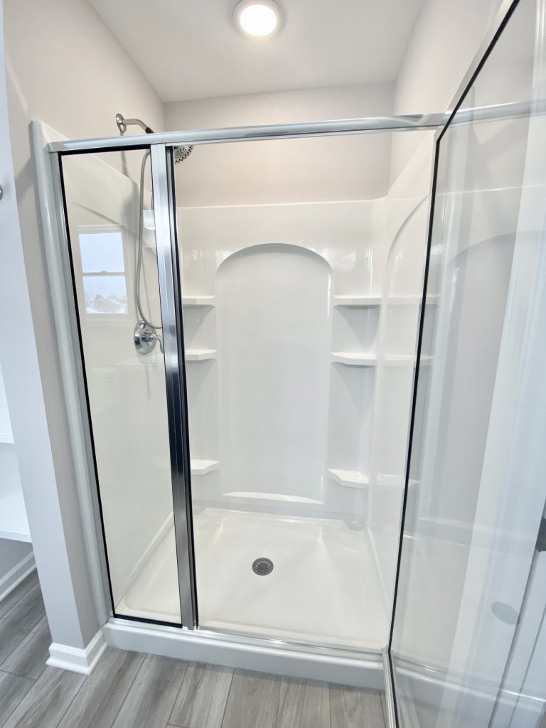 The Cooper I Walk-In Shower with Glass Doors, Built-In Shelves, White Surround & Tile Flooring