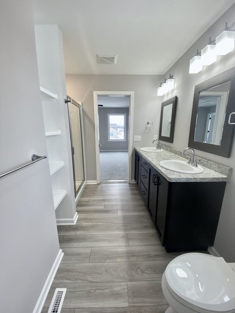 The Cooper I Primary Bathroom with Double Vanity, Glass Shower, Tile Flooring & Bedroom View