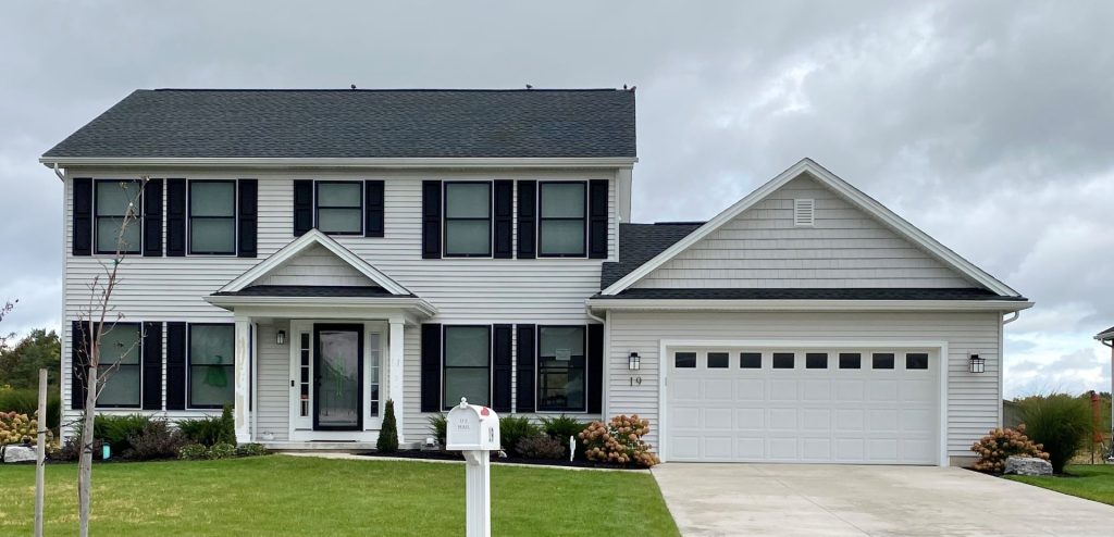 The Cooper I Model Home with Light Siding, Dark Shutters, Covered Front Porch & 2-Car Garage