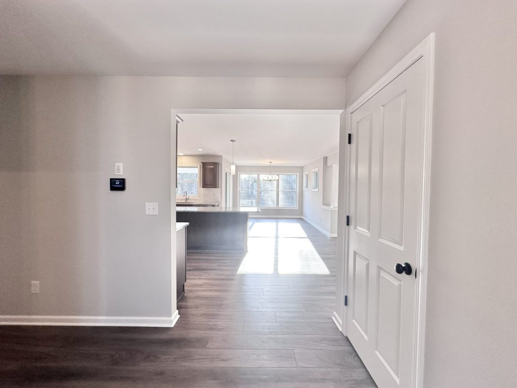 Golden-Interior-Hallway-with-Wood-Look-Flooring-and-Kitchen-Entry-View