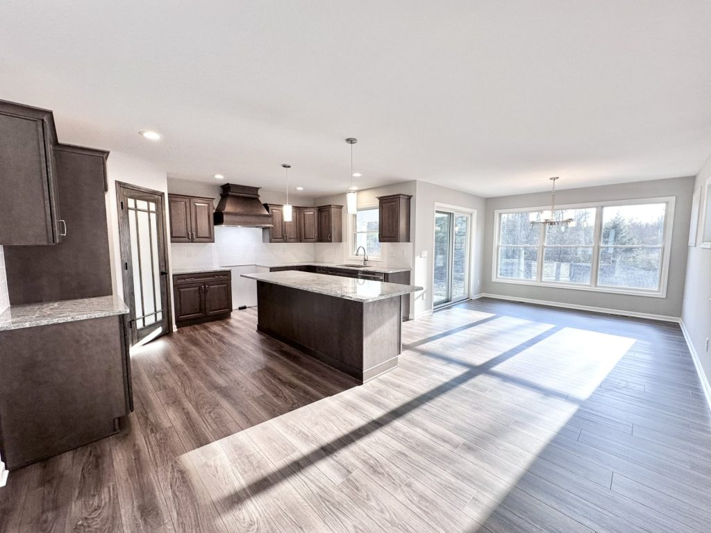 Golden-Kitchen-and-Dinette-with-Dark-Cabinetry-Large-Island-Sliding-Glass-Door-and-Picture-Window-Wall
