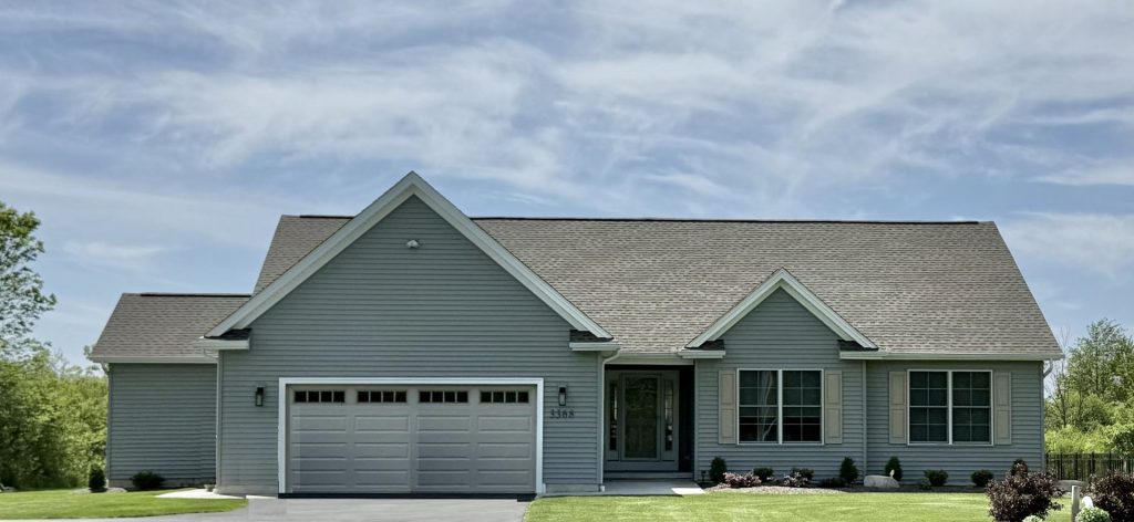 The Golden 1-Story Home Exterior with Gray Siding, Light Shutters, Covered Front Porch & 2-Car Garage