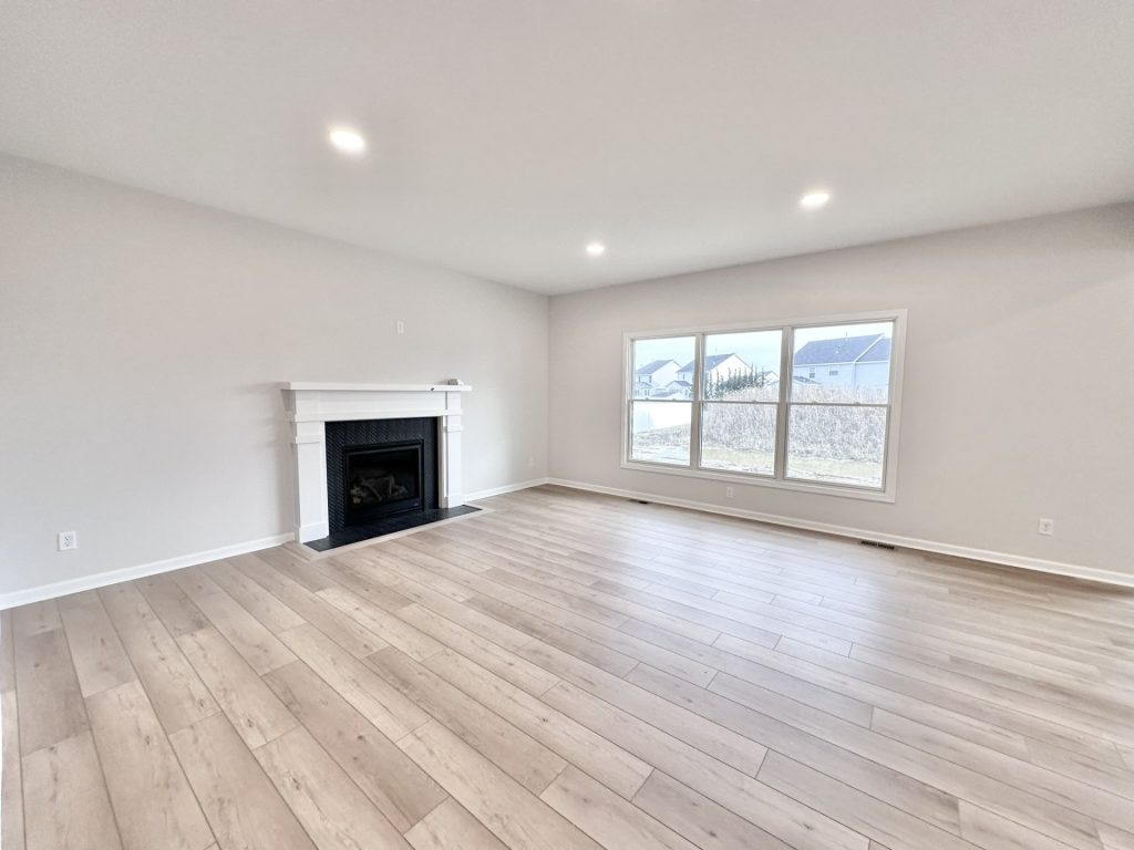 Cooper-Great-Room-White-Mantel-Fireplace-Wide-Plank-Flooring-Picture-Window