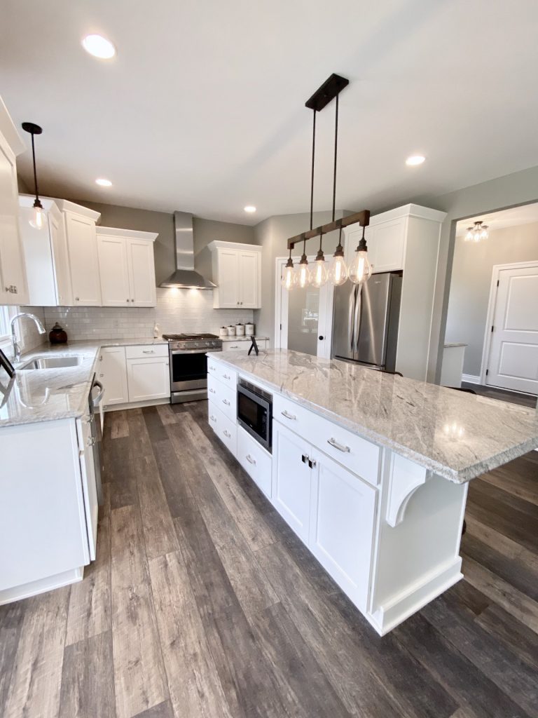 Weston-Kitchen-with-Large-Center-Island-White-Cabinetry-Granite-Counters-and-Wood-Look-Flooring