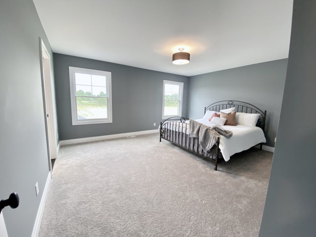 Weston-Primary-Bedroom-with-Gray-Walls-Neutral-Carpet-and-Double-Windows